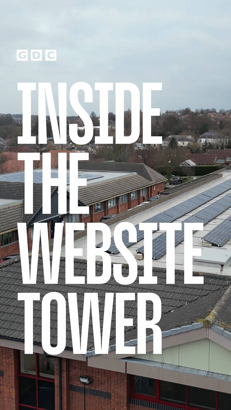 A drone shot of the top of an industrial area looking down with solar a panelled roof. Large text covering the majority of the image reads “GDC Inside the website tower”.